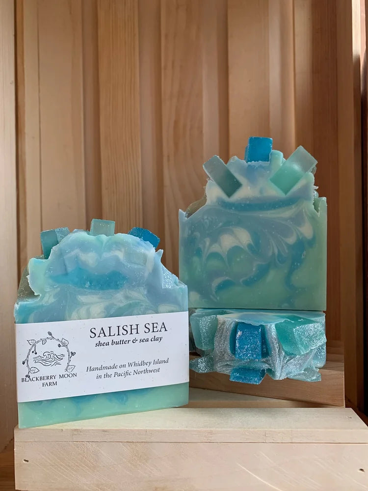 Salish Sea handmade soap bars with blue and green ocean swirl design displayed on a wooden stand. 